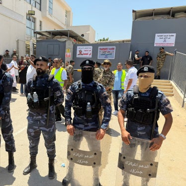 Security personnel stand guard as protesters gather outside the headquarters of the United Nations High Commissioner for Refugees (UNHCR), demanding the organization leave the country and calling for an end to migrant settlement and the deportation of migrants and refugees, in Tripoli, Libya, June 4, 2026. Picture taken with a mobile phone. 