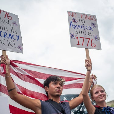 Protesters hold US flags and placards during a nationwide "No Kings" rally