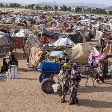 Displaced Sudanese people who fled El-Fasher after the city fell to the Rapid Support Forces (RSF), walk in the Um Yanqur camp, located on the southwestern edge of Tawila, in western Darfur, on November 3, 2025.