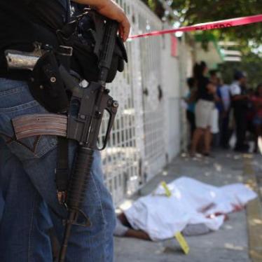 A policeman watches a covered body