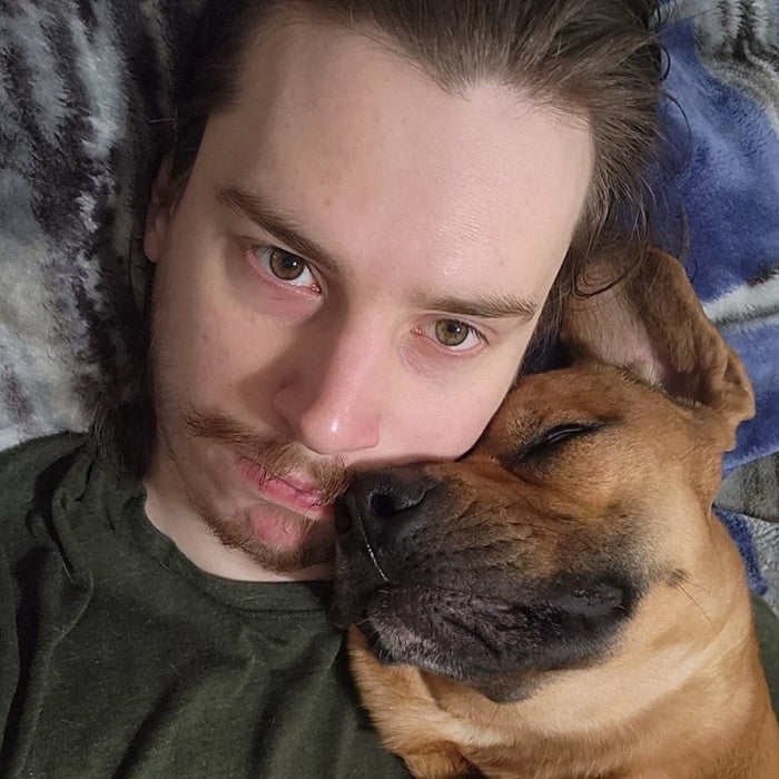 A man posing for a photo with a dog